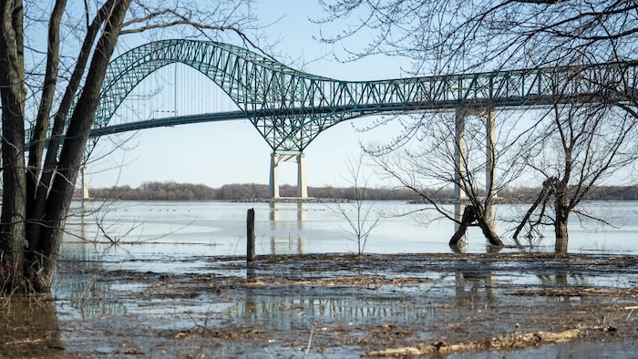 L'eau du fleuve, devant le pont Laviolette, déborde de son lit et gagne la terre ferme. 