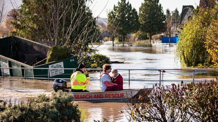 People are rescued by boat Tuesday from an area of Abbotsford that was cut off due to flooding.