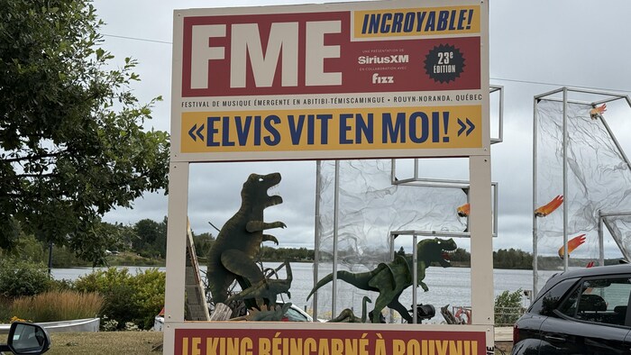 Des dinosaures dans un décor de festival.