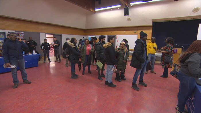 Des personnes attendent dans une file dans un corridor, le 22 février 2025 à Winnipeg.