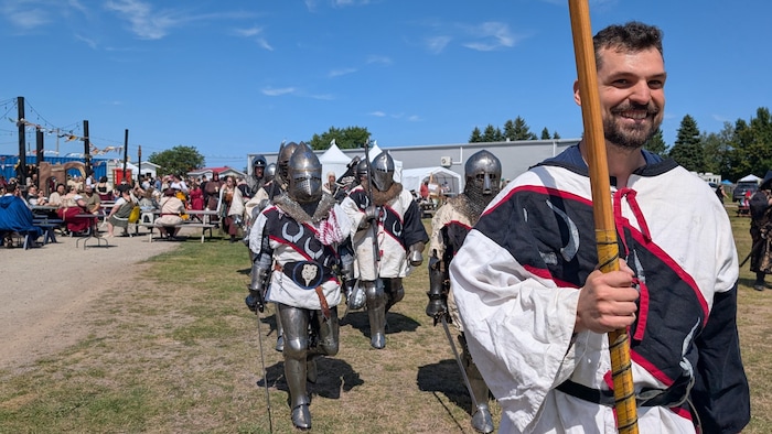 Des hommes en armure du Moyen-Âge, épée à la main. 