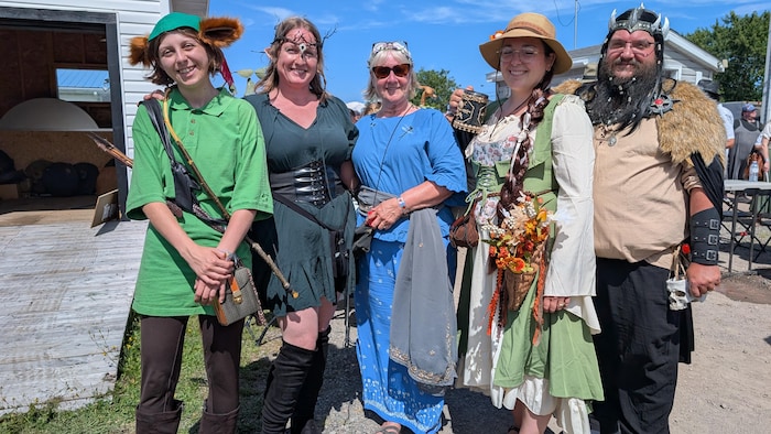 Cinq personnes portant des costumes inspirés du Moyen-Âge.