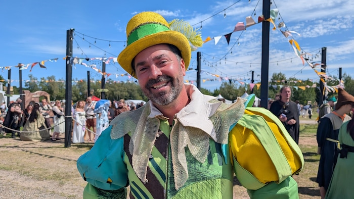 Un homme souriant portant un costume inspiré de la Renaissance.