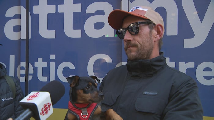 Roy Leclair en entrevue, son petit chien dans ses bras.