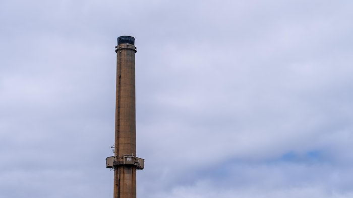 Une vue de la partie supérieure d'une grande cheminée industrielle en béton.