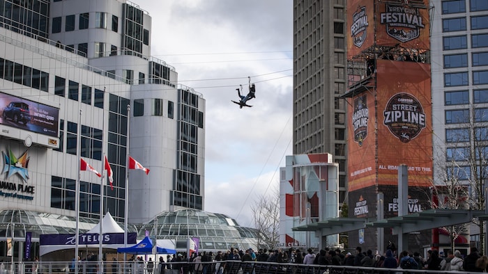 Des gens font de la tyrolienne depuis un échafaudage pendant le festival de la Coupe Grey avant la 111e Coupe Grey à Vancouver, en Colombie-Britannique.