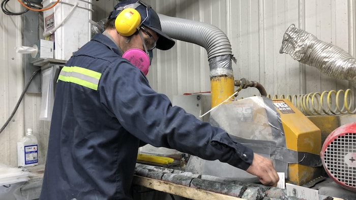 Un ouvrier coupe des morceaux de pierre dans une usine.
