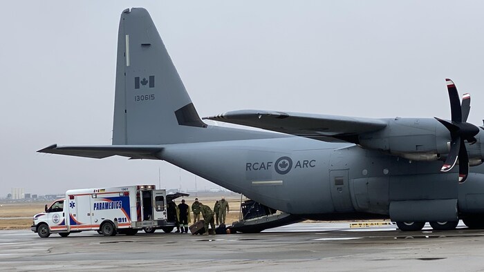 Transfert de matériel entre une ambulance et un avion militaire des Forces armées canadiennes en Saskatchewan.