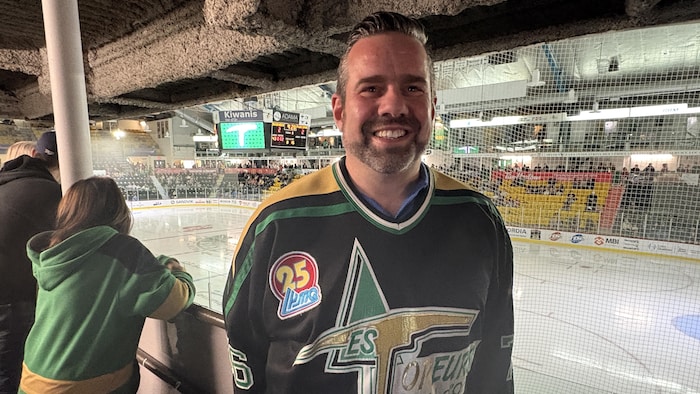 Dany Marchand, souriant et portant un chandail des Foreurs, dos à la glace.