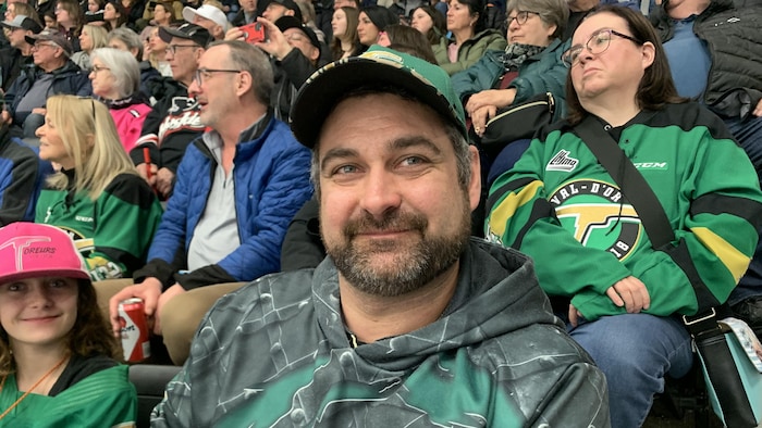 Une personne sourit avec sa casquette des Foreurs sur la tête.