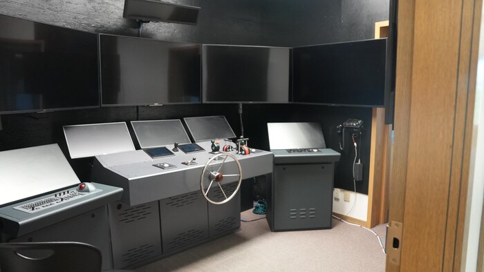 Une salle avec un simulateur de navigation maritime.