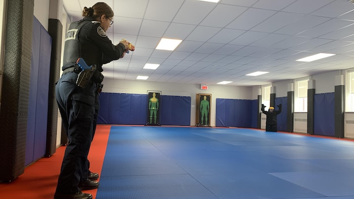 Une policière fait une intervention auprès d'une personne dans le cadre d'une simulation.
