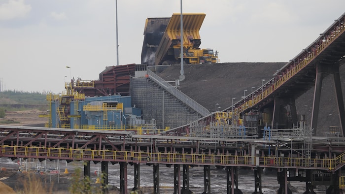 Des camions déversent des sables bitumineux dans la nouvelle mine Fort Hills de Suncor.