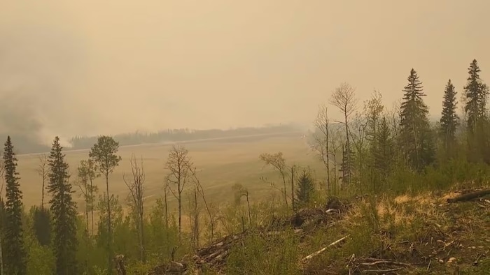 Un ciel rempli de fumée provenant d'un feu de forêt près de Fort Nelson.