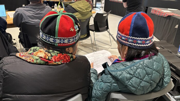 Deux personnes de dos regardent un document.