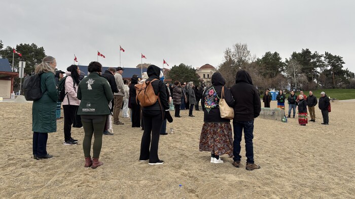 Des gens rassemblés pour la cérémonie de l’eau à la plage de Tugboat Bay, à Kelowna, le 24 mars 2026.