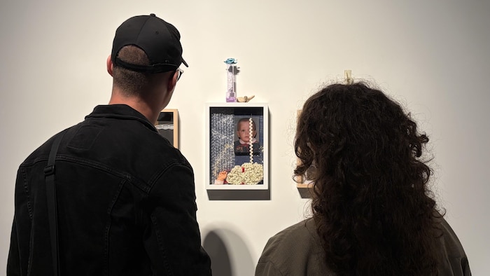 Vue de dos de deux personnes dans une galerie d'art.