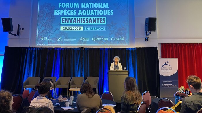 Une personne parle sur une scène.