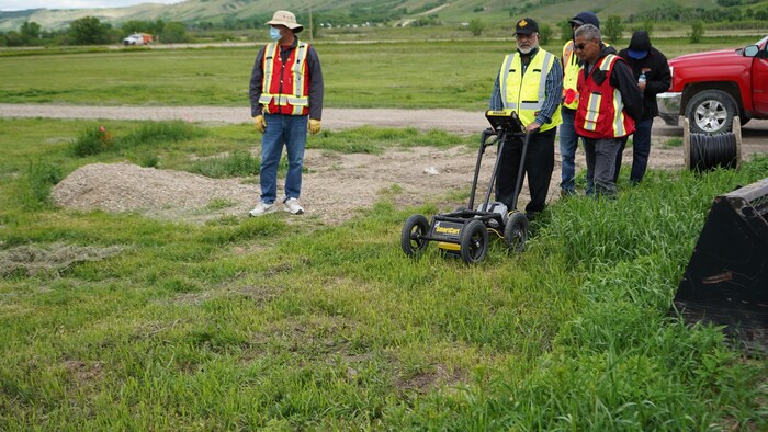 Des membres de la Première Nation de Cowessess sont sur le site de l'ancien pensionnat pour Autochtones de Marieval. L'un deux effectue une fouille radar.