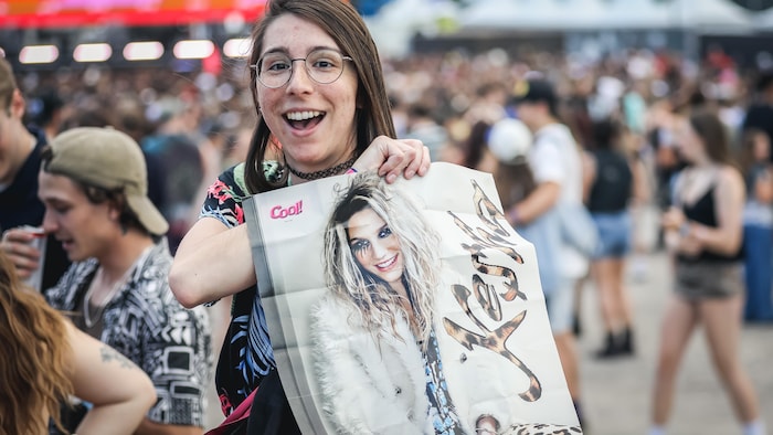 Une jeune femme tenant une affiche de Kesha avant son spectacle sur les plaines d'Abraham.