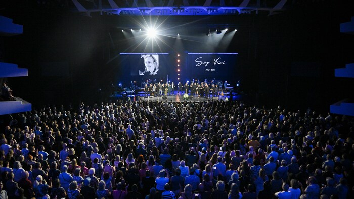 Une foule devant une scène remplie d'artistes.
