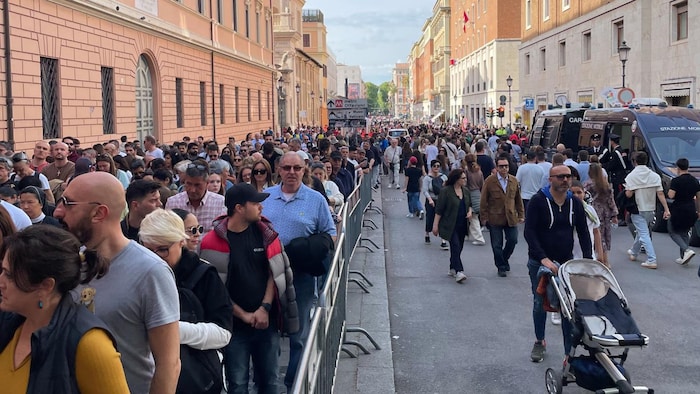 Des centaines de personnes font la queue dans la rue.