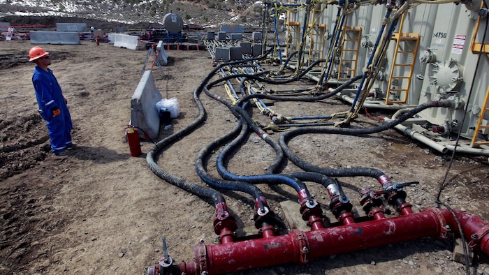 En mars 2013, un ouvrier surveillait des réservoirs et des tuyaux servant à l'extraction de gaz de schiste à Rifle, dans l'ouest du Colorado.