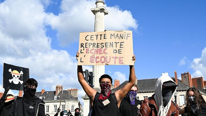 Un manifestant tient une pancarte sur laquelle on peut lire « cette manif représente l'échec de l'écoute ».