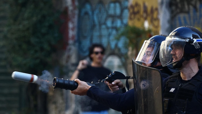 La police française lance une grenade lacrymogène lors d’affrontements avec des manifestants.
