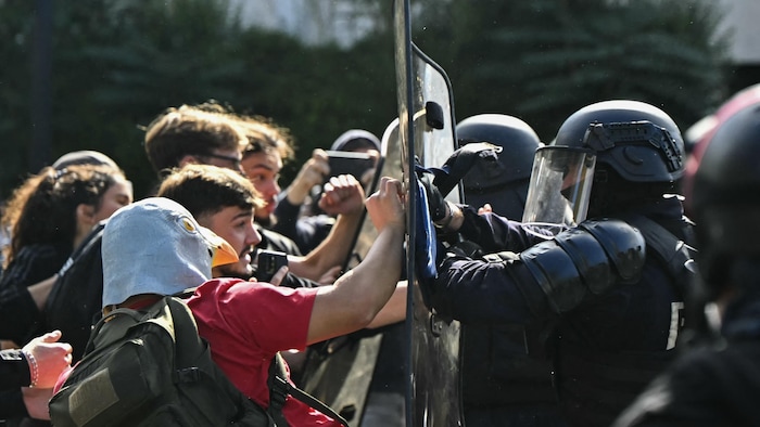 Des policiers antiémeutes font face à des lycéens en manifestation qui mènent une action de blocage devant le lycée Le Corbusier, à Aubervilliers, au nord de Paris.