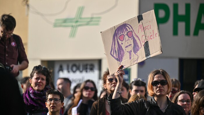 Une femme brandit une pancarte avec le portrait de Gisèle Pelicot lors d'une manifestation pour la Journée des droits des femmes à Paris, en France, le 8 mars 2026.