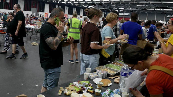 Des personnes évacuées se servent à manger.