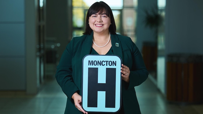 Frances LeBlanc, souriante, tient une affiche de l'hôpital.