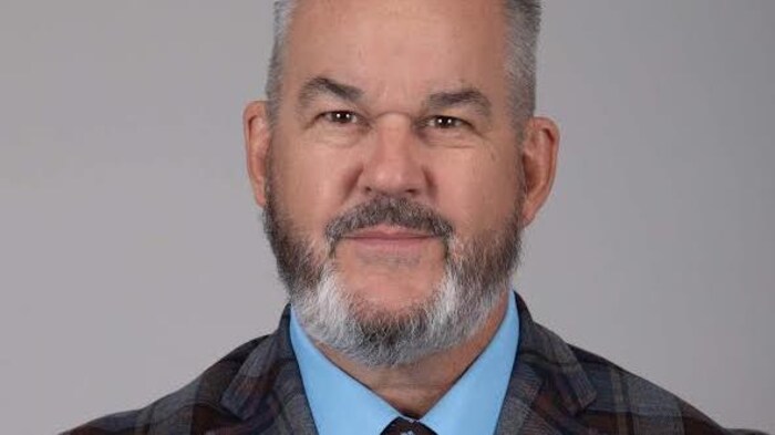 Francis Beauvais fixe l'objectif sur une photo officielle.
