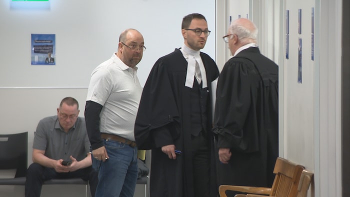 Un avocat et son client dans un corridor.