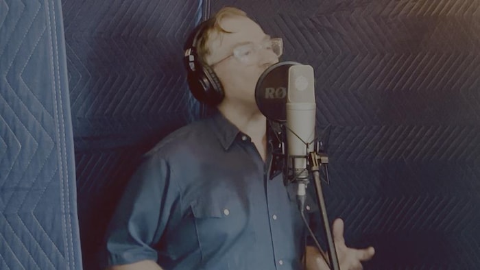 Francis Marchildon qui chante face à un micro, en 2025.