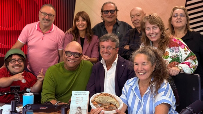 Un groupe de personnes pose et sourit. 