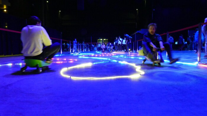 Des jeunes qui font une course avec des mini voitures.