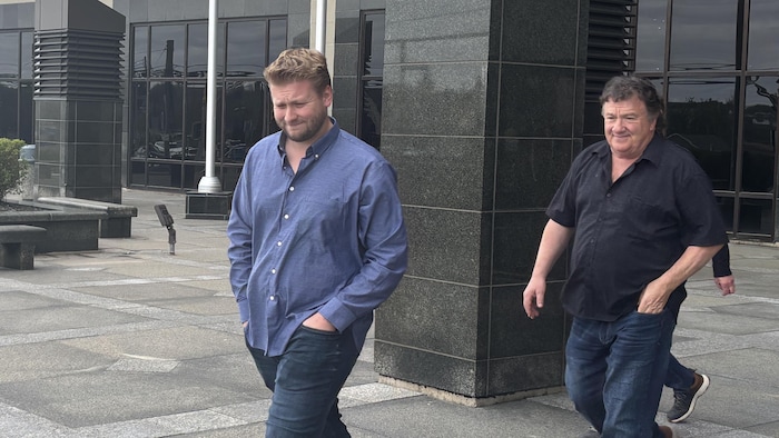 Deux hommes à leur sortie du palais de justice de Moncton.