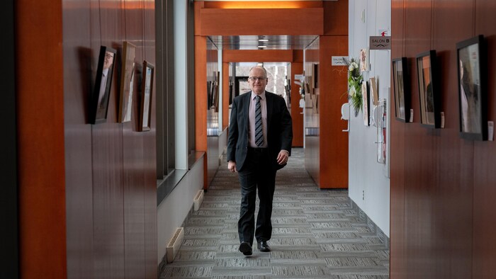 François Fouquet marche dans un corridor.