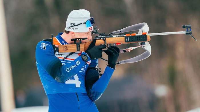 Sa carabine appuyée sur l'épaule, il se prépare à tirer. 