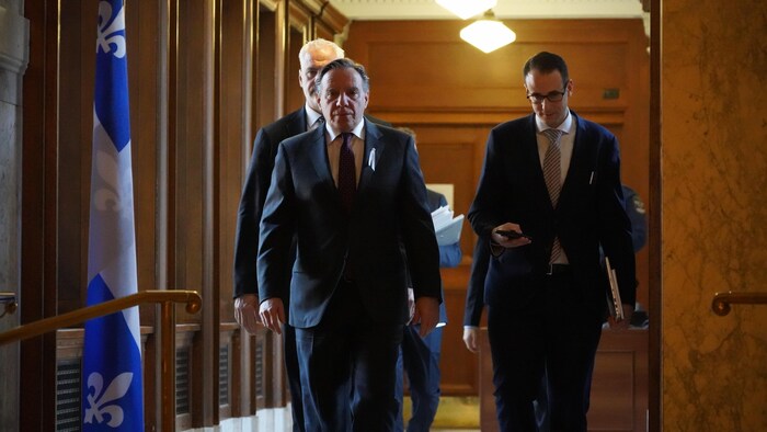 M. Legault et sa garde rapprochée arpentant les corridors de l'Assemblée nationale.