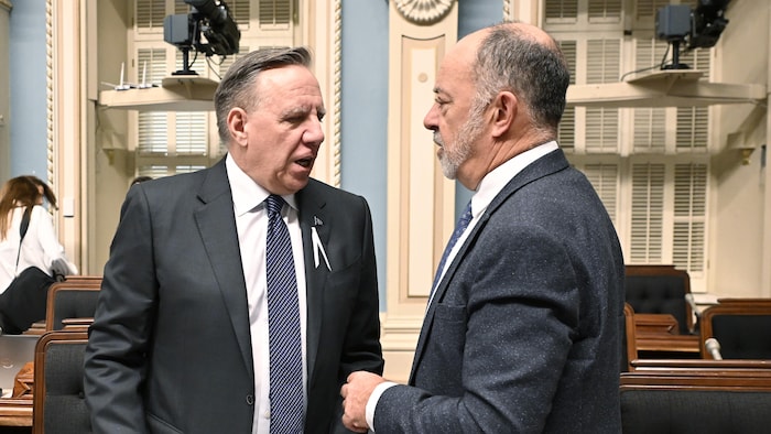 François Legault discute debout avec Christian Dubé.