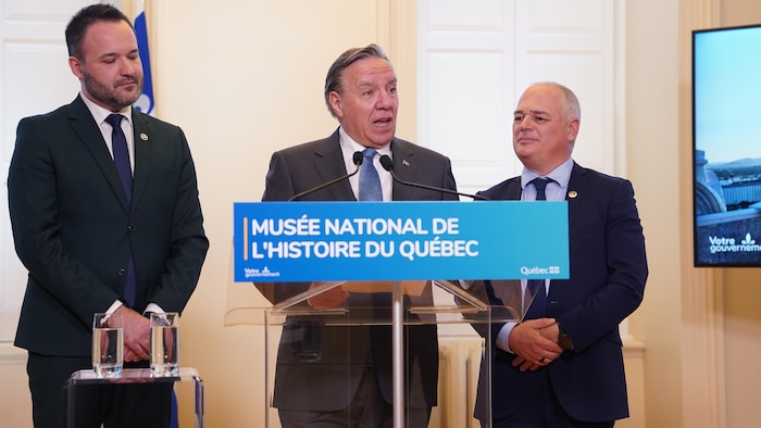 François Legault entouré du ministre de la Culture et des Communications, Mathieu Lacombe, et du ministre responsable des Infrastructures et ministre responsable de la
région de la Capitale-Nationale, Jonatan Julien.