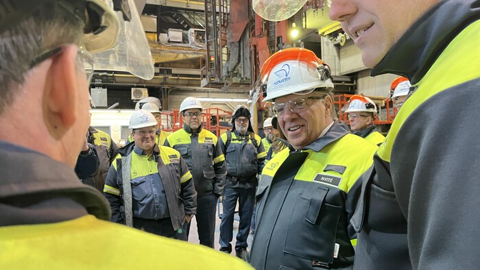 François Legault est entouré de travailleurs à l'aluminerie Alouette.