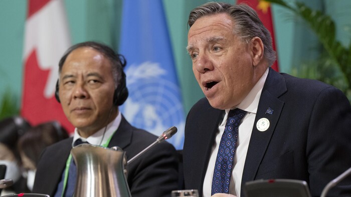 François Legault (à droite) et Wang Xiangang (à gauche) assis durant une conférence de presse.