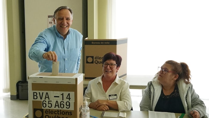 François Legault dépose son bulletin de vote dans une boîte.