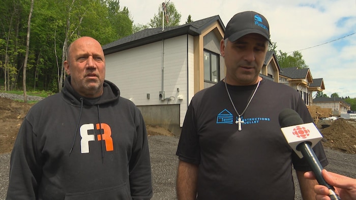 Deux hommes regardent la caméra en entrevue à Radio-Canada.