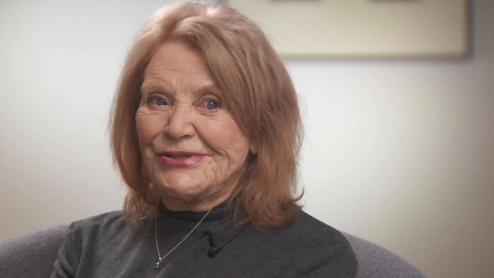 Françoise Sullivan est assise et regarde une autre personne près d'elle.