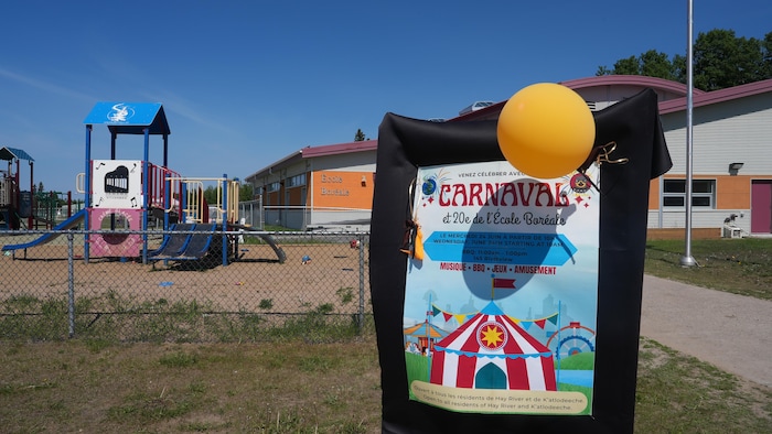 Une affiche annonçant le carnaval en premier plan et l'École Boréale en second plan.